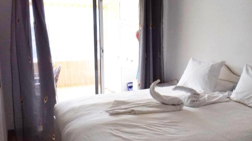 a bedroom with a bed with white sheets and a window at Apartamento Alegria in Playa del Cura