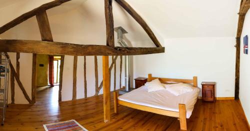a bedroom with a bed in a room with wooden floors at Le Pigeonnier @ Le Prielle in Madiran