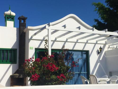 a white building with a flower pot on it at Hyde Park Lane in Puerto del Carmen