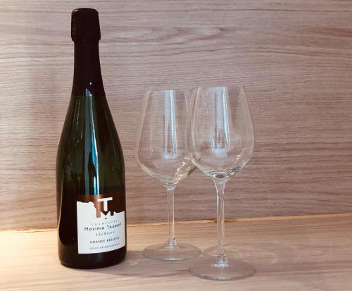 a bottle of wine next to three wine glasses at Charmant studio loft - Mas Bois Fontaine in Nîmes