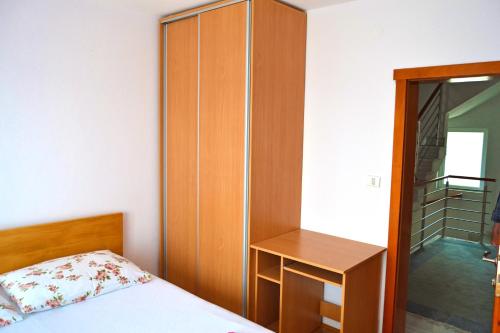 a bedroom with a bed and a wooden cabinet at Tivat Apartments in Tivat
