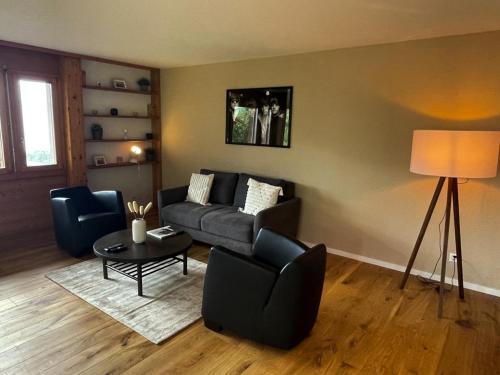 sala de estar con sofá y mesa en Panorama Boutique Apartment with complimentary Spa access at Solbad Hotel en Sigriswil