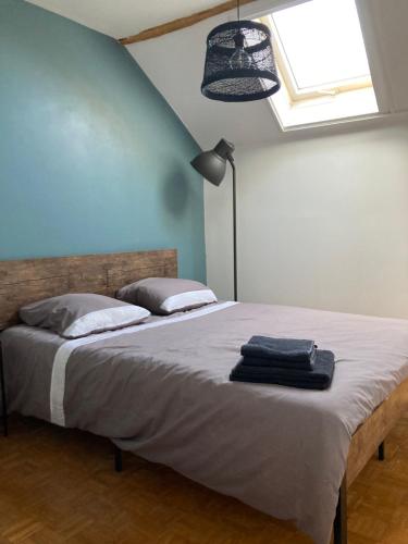 a bedroom with a large bed with a blue wall at L'Auberge des Clés in Chevannes