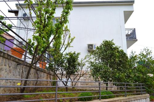 a white building with stairs and trees in front of it at Tivat Apartments in Tivat