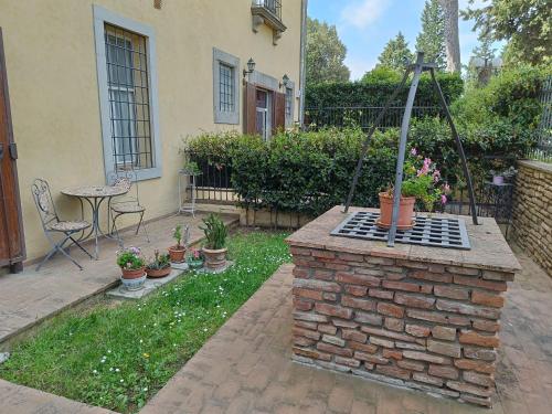 a backyard with a brick grill with potted plants at Villa Il Poggiale in Empoli