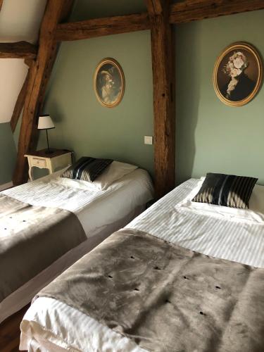 deux lits dans une chambre aux murs verts dans l'établissement Cottage du vigneron, à Vernou-sur-Brenne