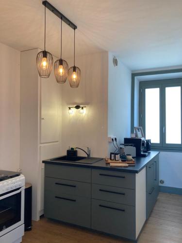 a kitchen with a counter with a sink and lights at MY BOUTIQUE GUESTHOUSE - Fabulous Suites 10 Min A7 - in Anneyron