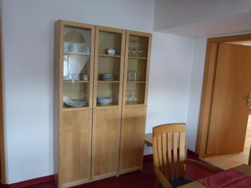 un armario de madera con platos junto a una mesa en Apartment Stasch, en Erlangen