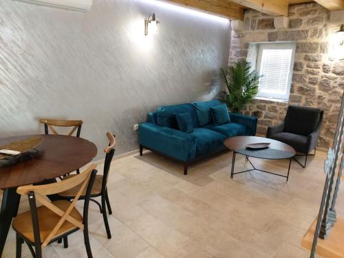 a living room with a blue couch and a table at Casa Vecchia in Kotor