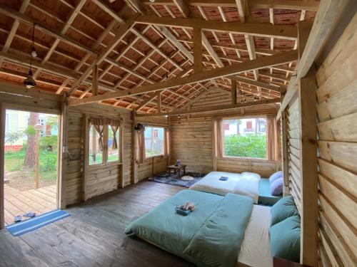 a room with two beds in a wooden house at La Maison Homestay Măng Đen in Kon Tum