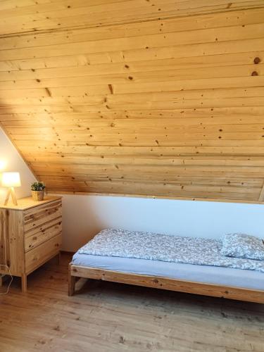 a bedroom with a bed and a wooden ceiling at Domek na Berechu Domek w Górach-Pieniny in Szlachtowa