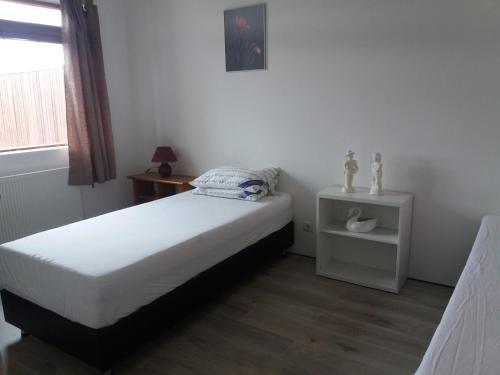 ein kleines Schlafzimmer mit einem Bett und einem Fenster in der Unterkunft Reykjavik Apartment Garden and Terrace in Reykjavík
