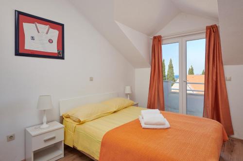 ツァヴタットにあるApartments Insulaのベッドルーム1室(オレンジの毛布、窓付)
