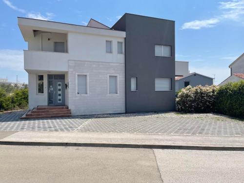 a large white house with a driveway at STUDIO apartment Doki BASEMENT in Pula