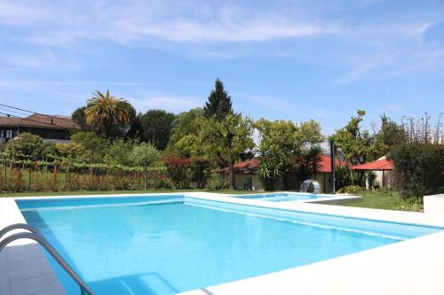 a large swimming pool in a yard at Hotel Solar das Laranjeiras in Vale de Cambra