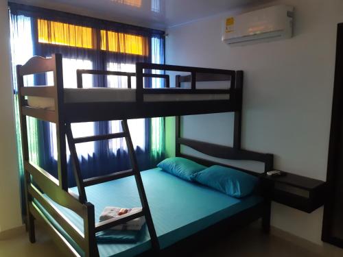 ein Etagenbett mit einer Leiter und einem Kissen in einem Zimmer in der Unterkunft Hospedaje casa Blanca, la mejor opción en Guaviare in San José del Guaviare
