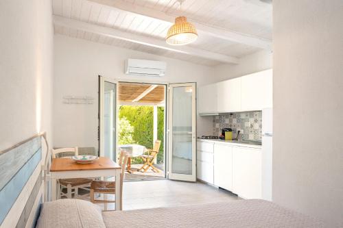 a kitchen and dining room with a table in a room at Il giardino di sabbia in Lacona