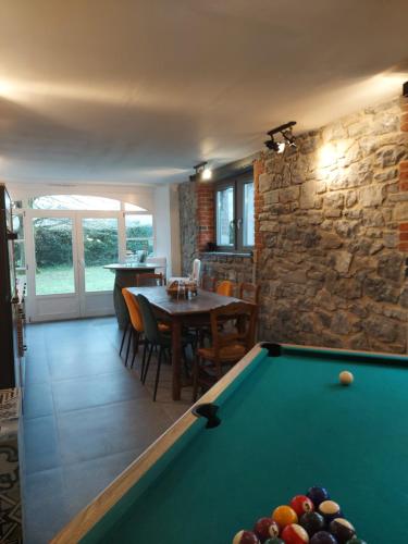 a living room with a pool table and a stone wall at Au Clos Caleste in Wellin
