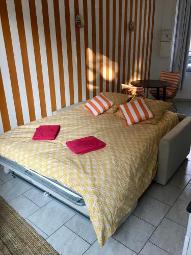 - un lit avec des oreillers rouges dans l'établissement Studio à 20m de la mer, à Mers-les-Bains