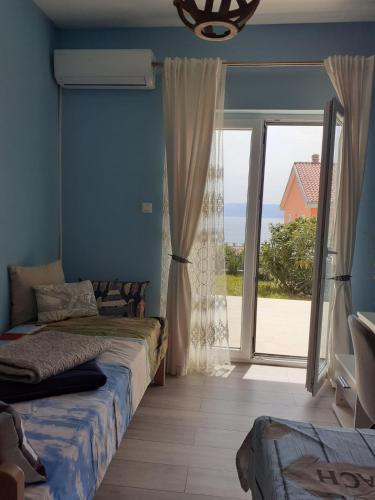 une chambre avec un lit et une grande porte coulissante en verre dans l'établissement LIGHTHOUSE, à Novi Vinodolski