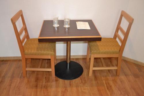 un tavolo di legno con due sedie e due bicchieri sopra di Hotel & Villas Panamá a Città del Messico