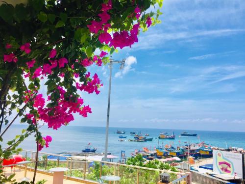 Blick auf den Strand mit rosa Blumen in der Unterkunft Binh Yen Hotel in Ly Son