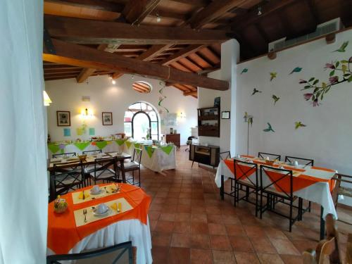 a restaurant with tables and chairs in a room at Agriturismo Bio Pian Dei Casali in Saturnia