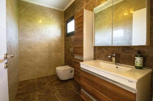 un baño con lavabo e inodoro en DELUXE VİLLA Kuşadası, en Kusadasi