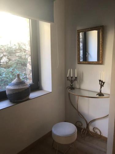 a bathroom with a window and a stool and a mirror at La Bergerie in Saint-Vincent