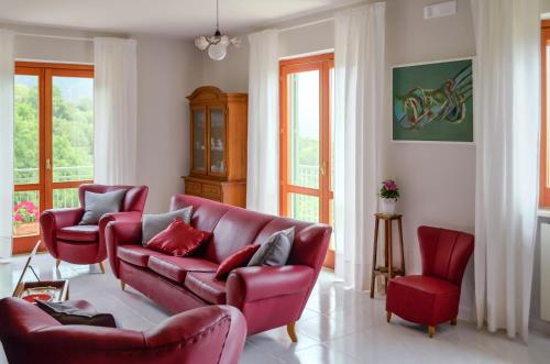sala de estar con sofá rojo y 2 sillas en Driùs edodè - b&b affittacamere, en Torraca