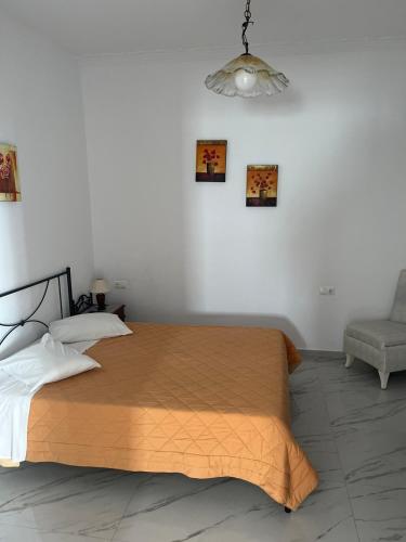 a bedroom with a large bed and a chair at Sofia Village in Mýkonos City