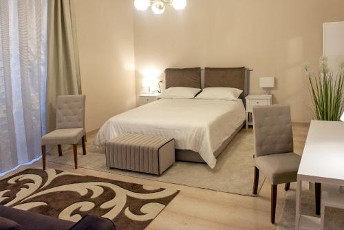 1 dormitorio con 1 cama y 2 sillas en Appartamento Romeo, nel cuore di Roma, en Roma