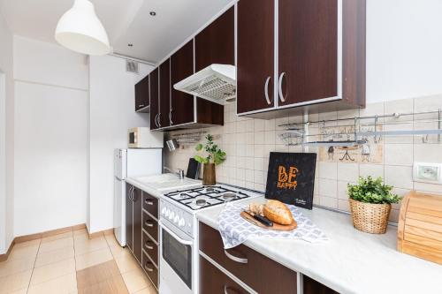 a kitchen with brown cabinets and a stove top oven at SuperApart Dzielna 9a in Warsaw
