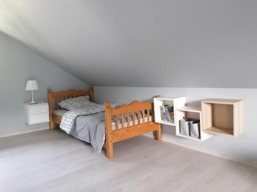 um quarto com uma cama de madeira e 2 prateleiras brancas em Dom wypoczynkowy Pod kasztanem 1 em Wartkowo