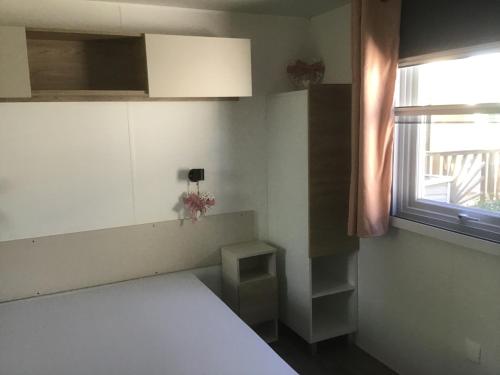 ein Schlafzimmer mit einem weißen Bett und einem Fenster in der Unterkunft La carabasse in Vias