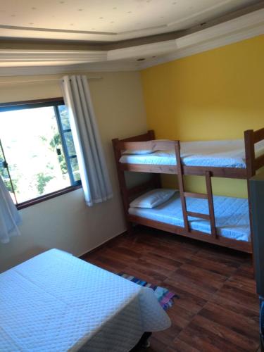 a room with two bunk beds and a window at Cobertura centro Ibitpoca MG in Lima Duarte