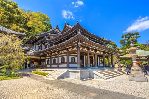 a building in a park with people walking around it at BIRD HOTEL in Kamakura