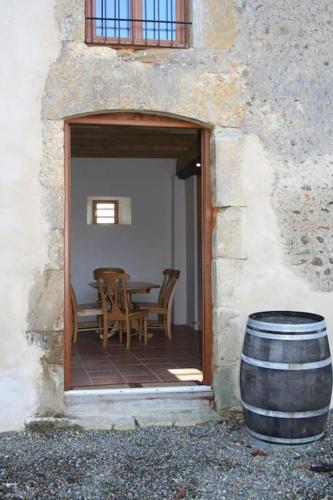 a patio with a table and chairs and a barrel at Le Pigeonnier @ Le Prielle in Madiran