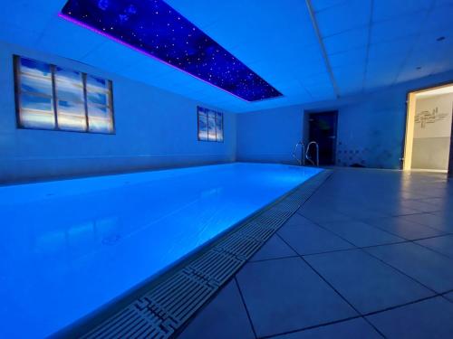 a swimming pool in a room with blue lights at Hotel garni Kleindienst in Ursensollen