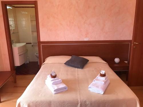 a bedroom with a bed with towels on it at Locanda della Corte in Roccamorice