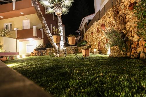 a green yard with palm trees and a building at Heaven Apartments in Agia Marina Nea Kydonias