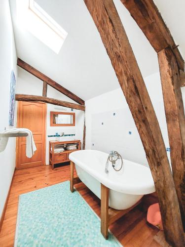a bathroom with a large white tub in a room at Le Pigeonnier @ Le Prielle in Madiran