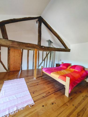 a bedroom with a bed in a room with wooden floors at Le Pigeonnier @ Le Prielle in Madiran