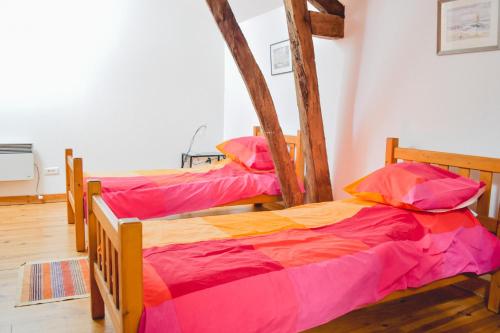 two twin beds in a room with wooden floors at Le Pigeonnier @ Le Prielle in Madiran