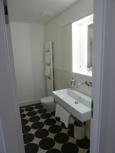 a bathroom with a sink and a toilet and a mirror at Hotel Lindenufer in Berlin