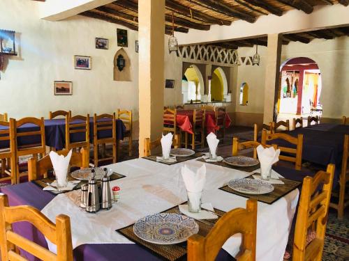 a dining room with a table and chairs at Riad Hotel Les Flamants in Merzouga