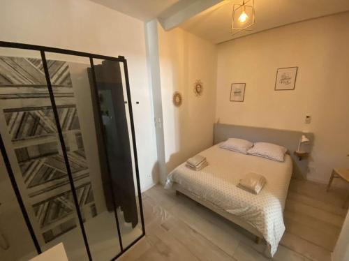 une petite chambre avec un lit et un miroir dans l'établissement La Vitrine des Arènes, à Arles