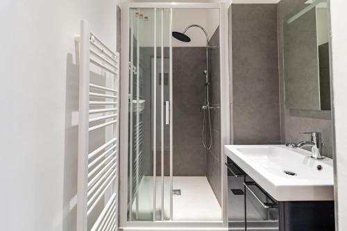La salle de bains est pourvue d'une douche et d'un lavabo. dans l'établissement LE PRIVILIANE - Bel et grand appartement idéalement situé, à Marseille