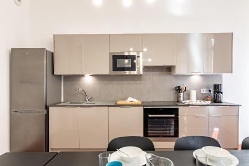 une cuisine avec des armoires blanches et une table et des chaises dans l'établissement LE PRIVILIANE - Bel et grand appartement idéalement situé, à Marseille