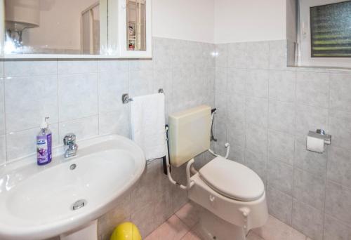 a bathroom with a white toilet and a sink at House Sun and Sea in Olib